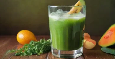 Jugo verde brillante en un vaso rodeado de frutas y verduras vibrantes