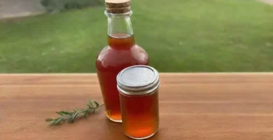 Botella de vinagre de manzana sobre una mesa de madera con luz suave